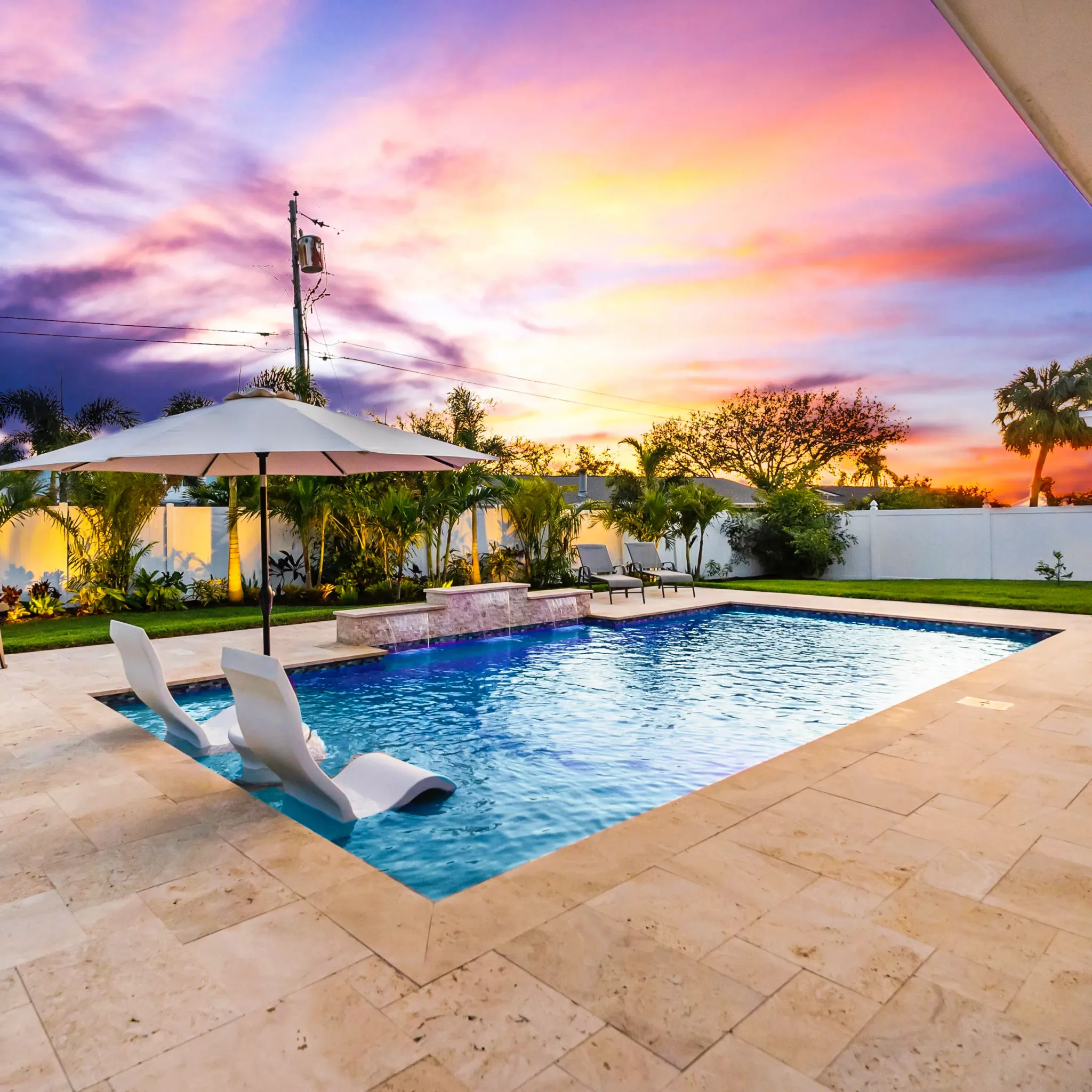 Custom concrete pool with tanning ledge in a Tampa Bay backyard