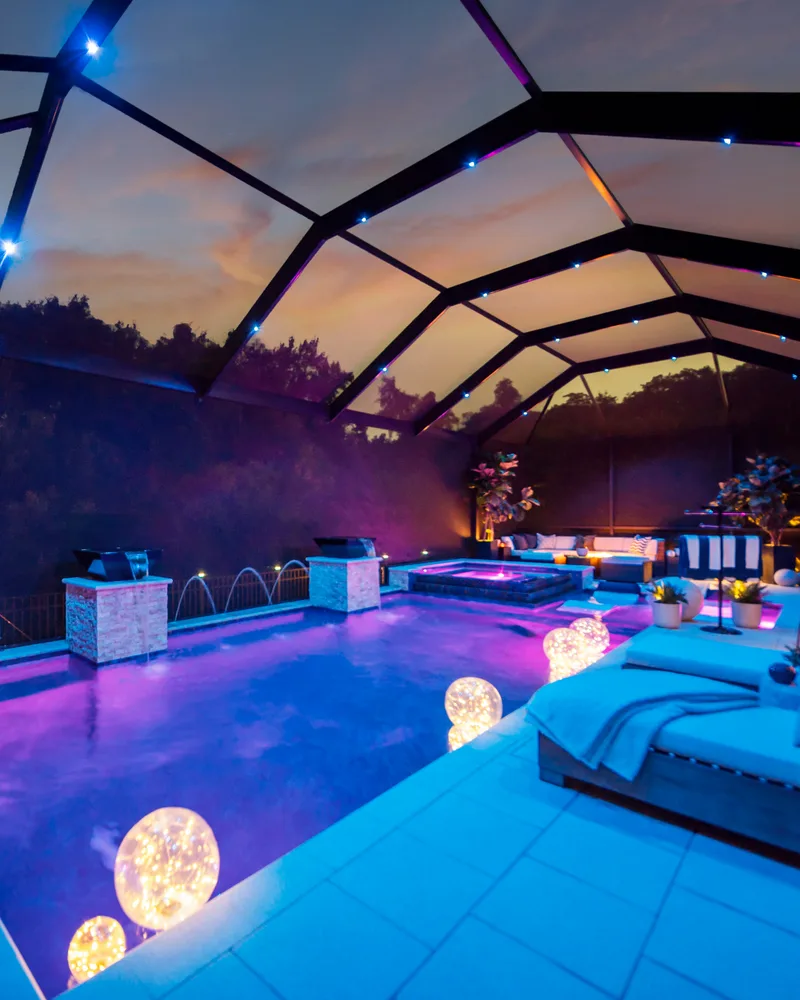 Three deck jets arcing across a lit pool at dusk