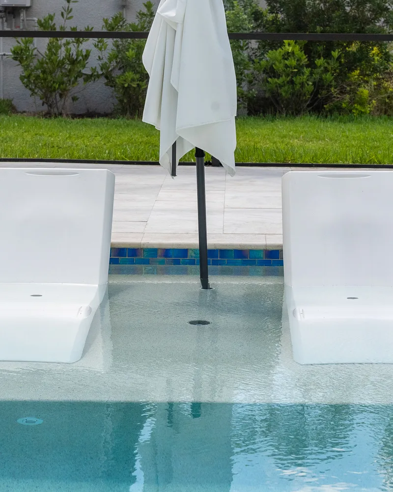 Custom pool and raised spa with Blue Lagoon glass tile built by Pool Perfection in Wesley Chapel