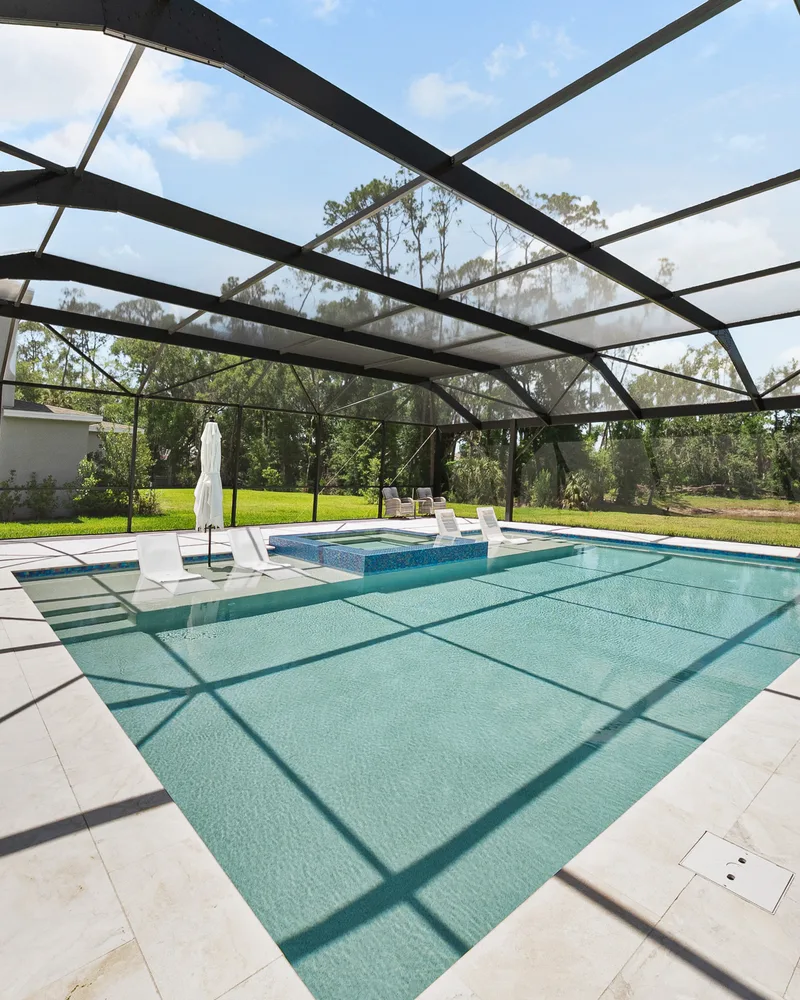 Custom pool and raised spa with Blue Lagoon glass tile built by Pool Perfection in Wesley Chapel