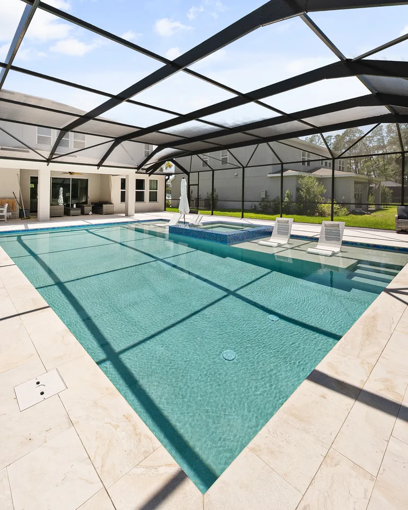 Custom pool and raised spa with Blue Lagoon glass tile built by Pool Perfection in Wesley Chapel