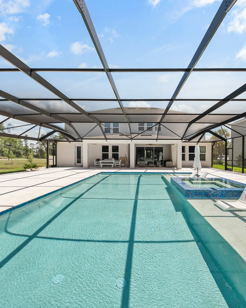 Custom pool and raised spa with Blue Lagoon glass tile built by Pool Perfection in Wesley Chapel
